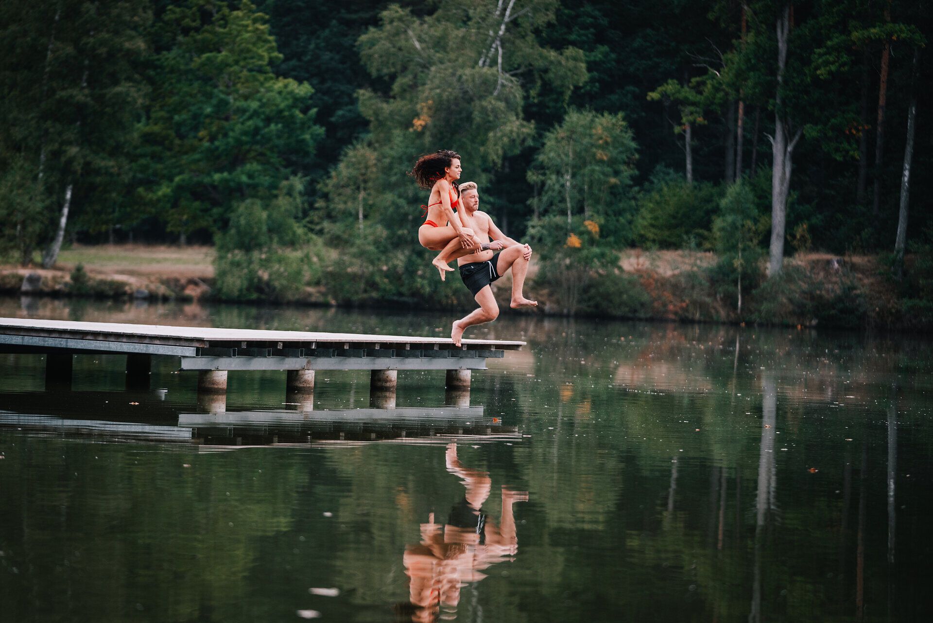 An einem warmen Sommertag springen fröhliche Menschen ins erfrischende Wasser des Herrensees. Umgeben von üppigem Grün und der ruhigen Atmosphäre des Waldes, bietet dieser Ort die perfekte Kulisse für unvergessliche Momente in der Natur.