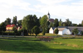 Ländliche Szene mit Kirche und Häusern in Haugschlag.