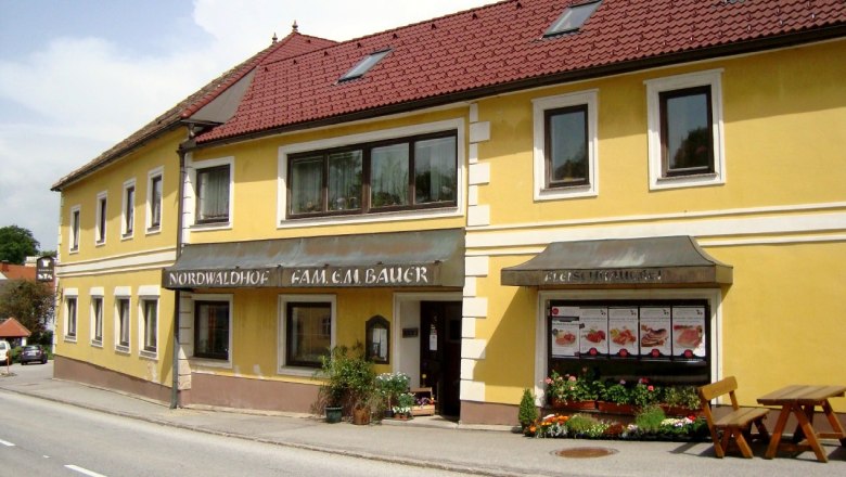 Nordwaldhof, © Nordwaldhof Gelbes Gebäude mit rotem Dach und Schildern 'Nordwaldhof' und 'Fleischhauerei'.