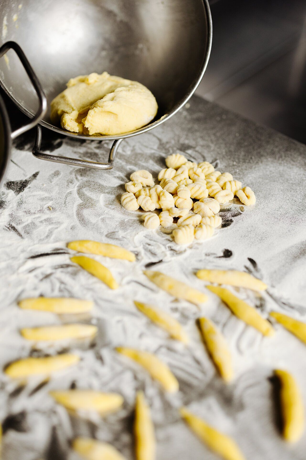 Die frischen Gnocchi und Mohnnudeln liegen bereit, um in ein köstliches Gericht verwandelt zu werden. Umgeben von einer sanften Mehlstaubschicht, strahlt die Küche eine einladende Atmosphäre aus, die zum Genießen einlädt. Hier wird die Tradition der österreichischen Küche lebendig.
