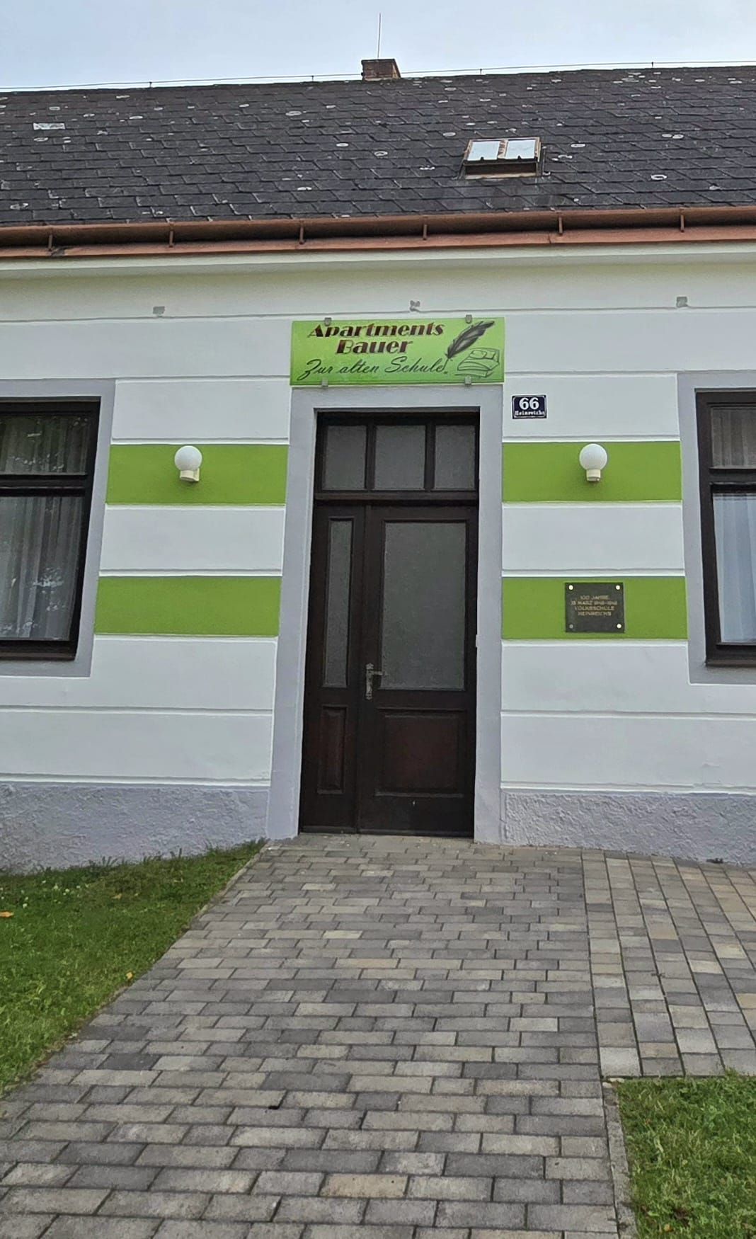 Eingang eines Hauses mit der Aufschrift 'Apartments Bauer Zur alten Schule'.