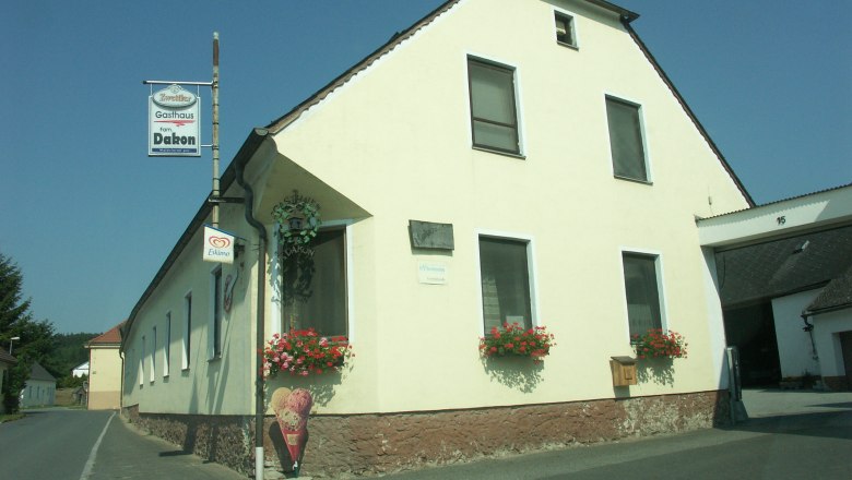 A yellow inn with flowers and an ice cream bar on a country road.