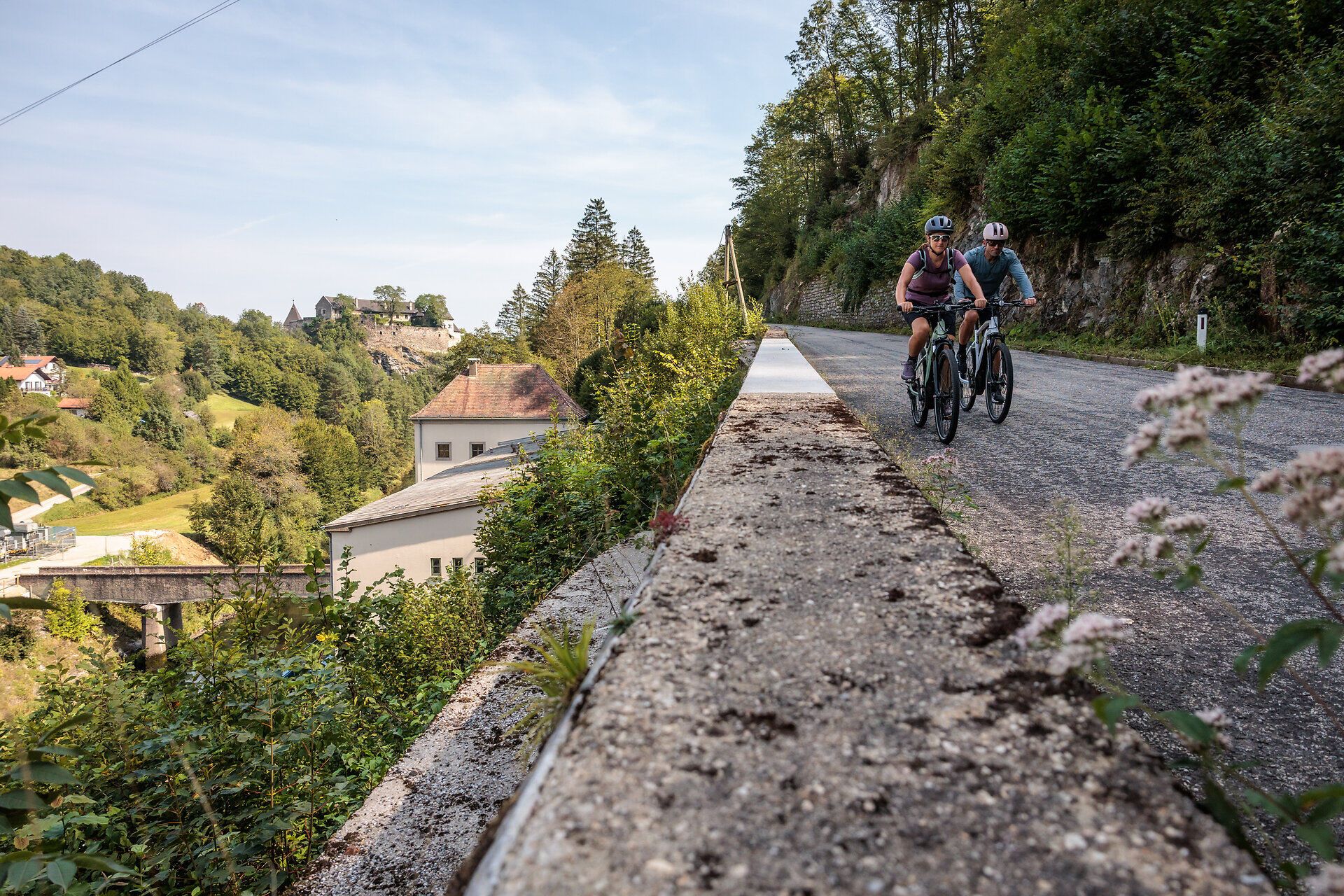 Radfahrer gleiten entlang des malerischen Kamptal Radwegs, umgeben von üppigem Grün und sanften Hügeln. Die frische Bergluft und die atemberaubenden Ausblicke laden dazu ein, die Schönheit der Natur in vollen Zügen zu genießen.