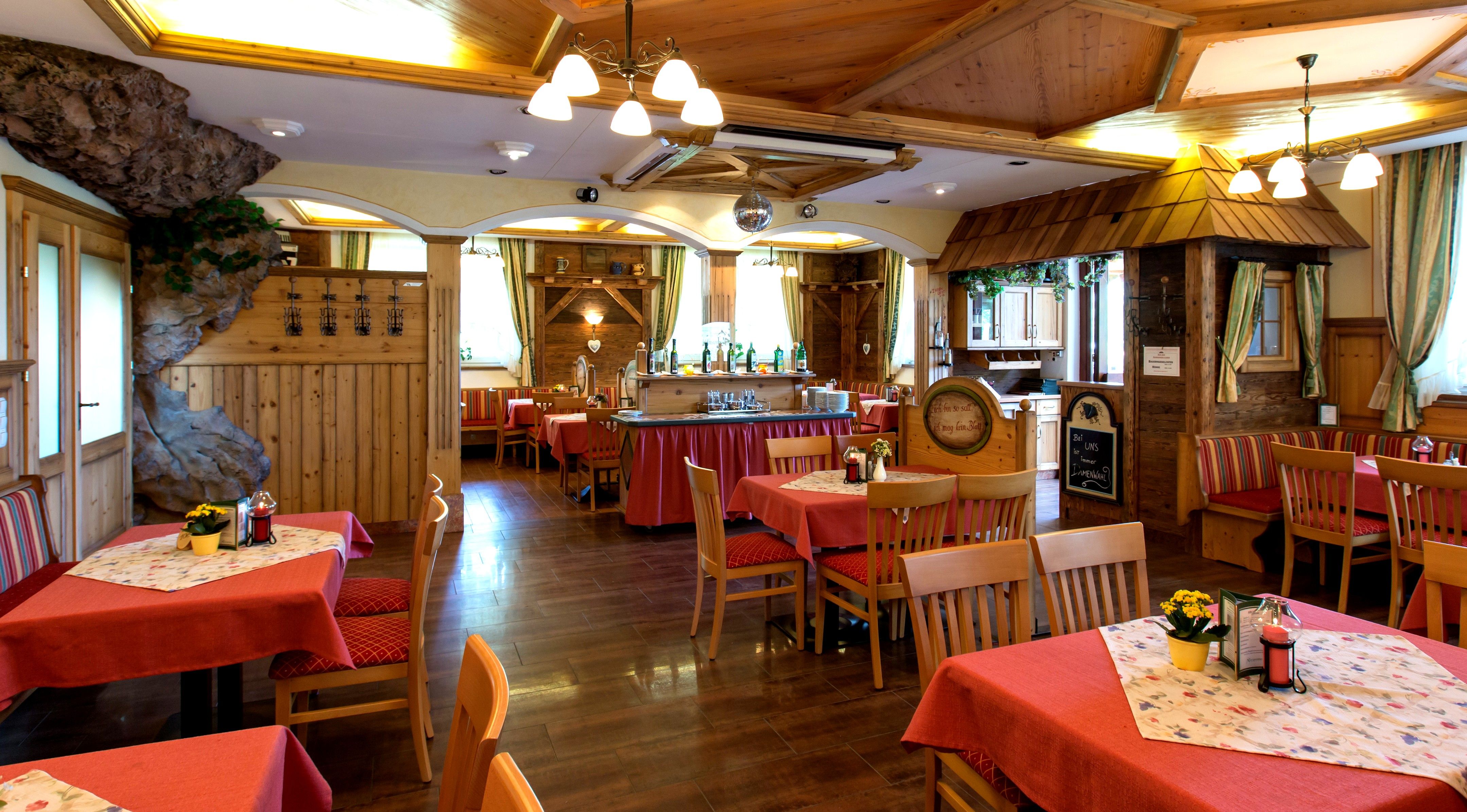 Ein gemütliches Hotelzimmer mit Holzboden, einem großen Bett, einem Schreibtisch und einem dekorativen Baldachin an der Decke.