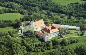 Luftaufnahme eines Klosters inmitten von grüner Landschaft.
