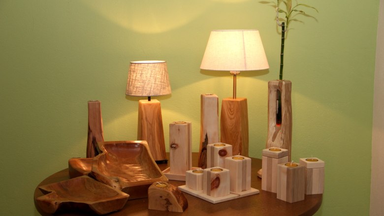Holzhandwerk mit Lampen und Kerzenhaltern auf einem Tisch.