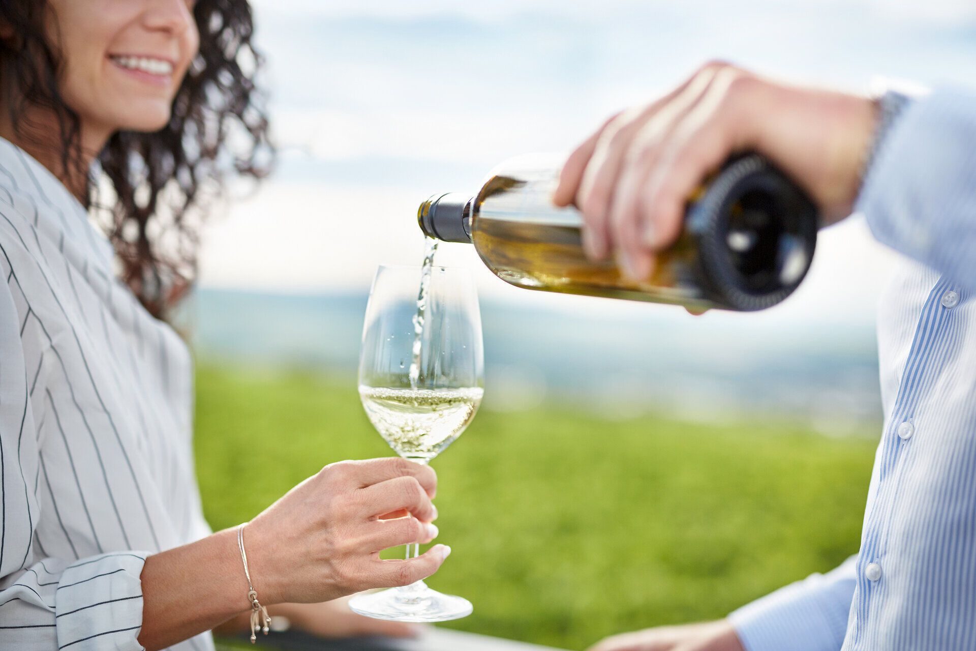 Inmitten der sanften Hügel des Kamptals genießen zwei Freunde ein Glas erfrischenden Weißwein, während die Sonne sanft über den Weinbergen untergeht. Die Atmosphäre ist entspannt und einladend, perfekt für einen geselligen Abend in der Natur.