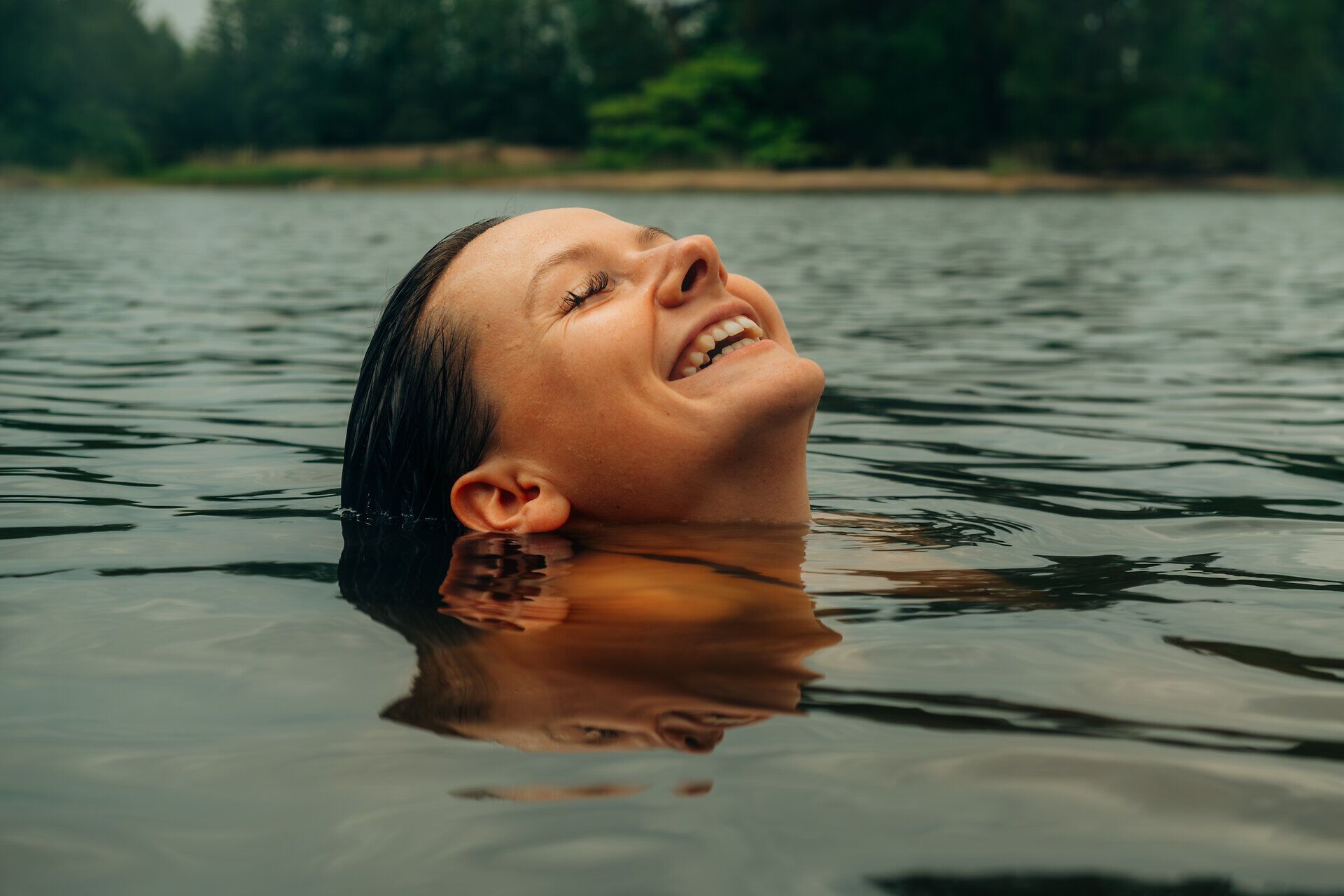 Kopf einer Frau, die lächelnd im Wasser ist