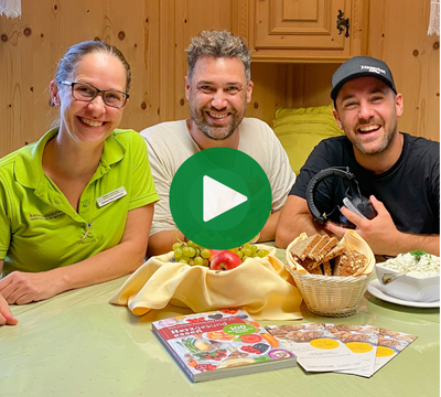 3 Personen mit gesunden Lebensmitteln mit Blick in die Kamera