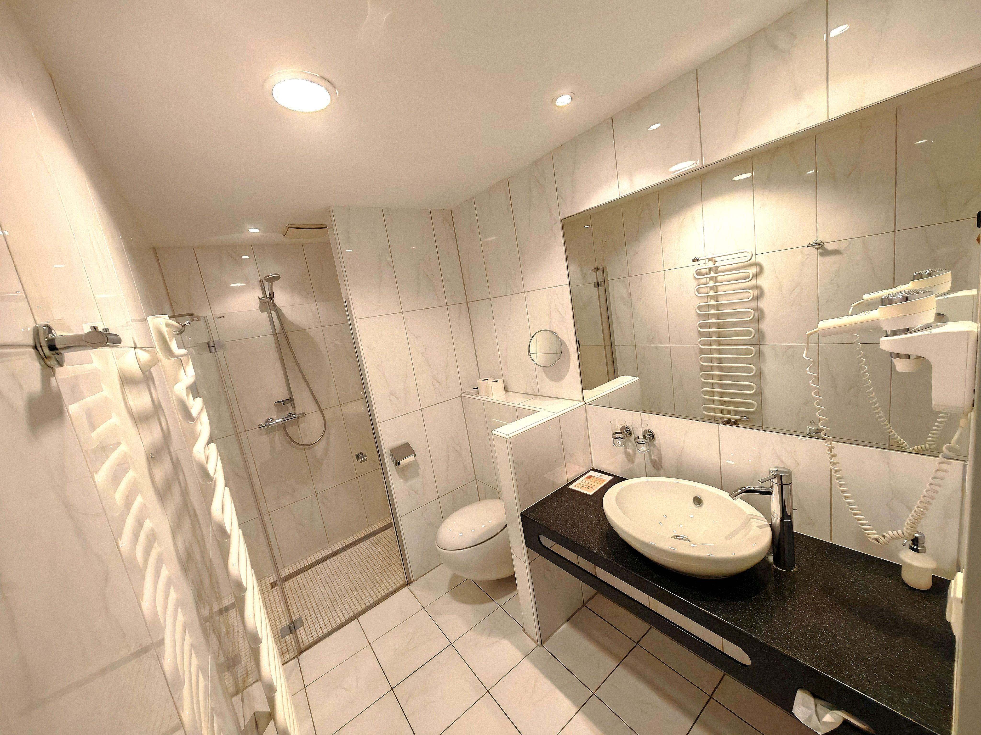 Modernes Badezimmer mit Dusche, Waschbecken und Toilette.