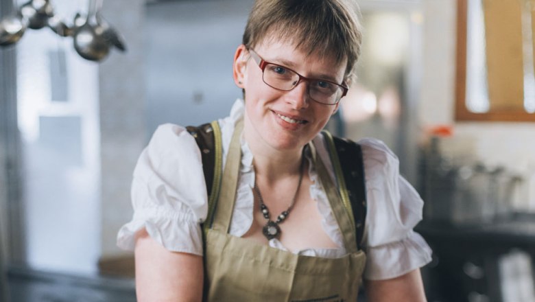 Frau in traditioneller Kleidung in einer Küche.