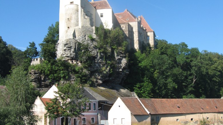 Burg Raabs an der Thaya auf einem Felsen über Häusern und einem Fluss.