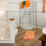Modernes Badezimmer mit Badewanne, Dusche und Doppelwaschbecken.