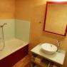 Modernes Badezimmer mit Badewanne, Waschbecken und Spiegel.