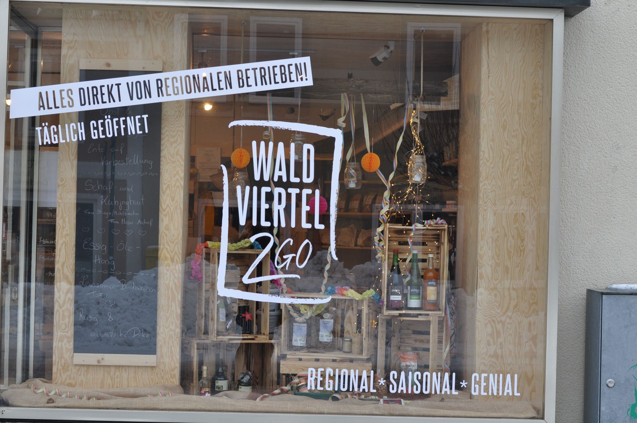 Schaufenster mit regionalen Produkten und Dekorationen, beschriftet mit 'Waldviertel 2 Go'.