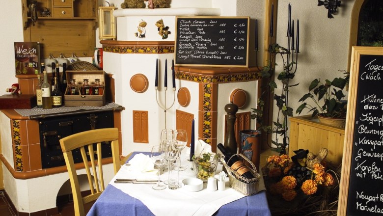 Cozy fireside lounge with set table, wine lists and decorations.