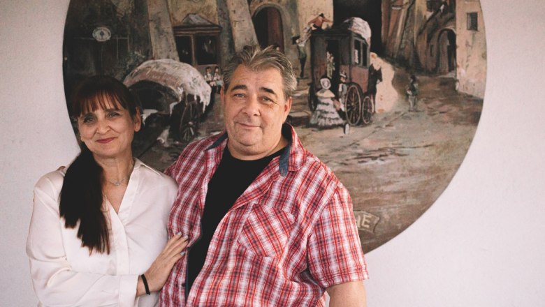 Ein Mann und eine Frau stehen vor einem Gemälde an der Wand.