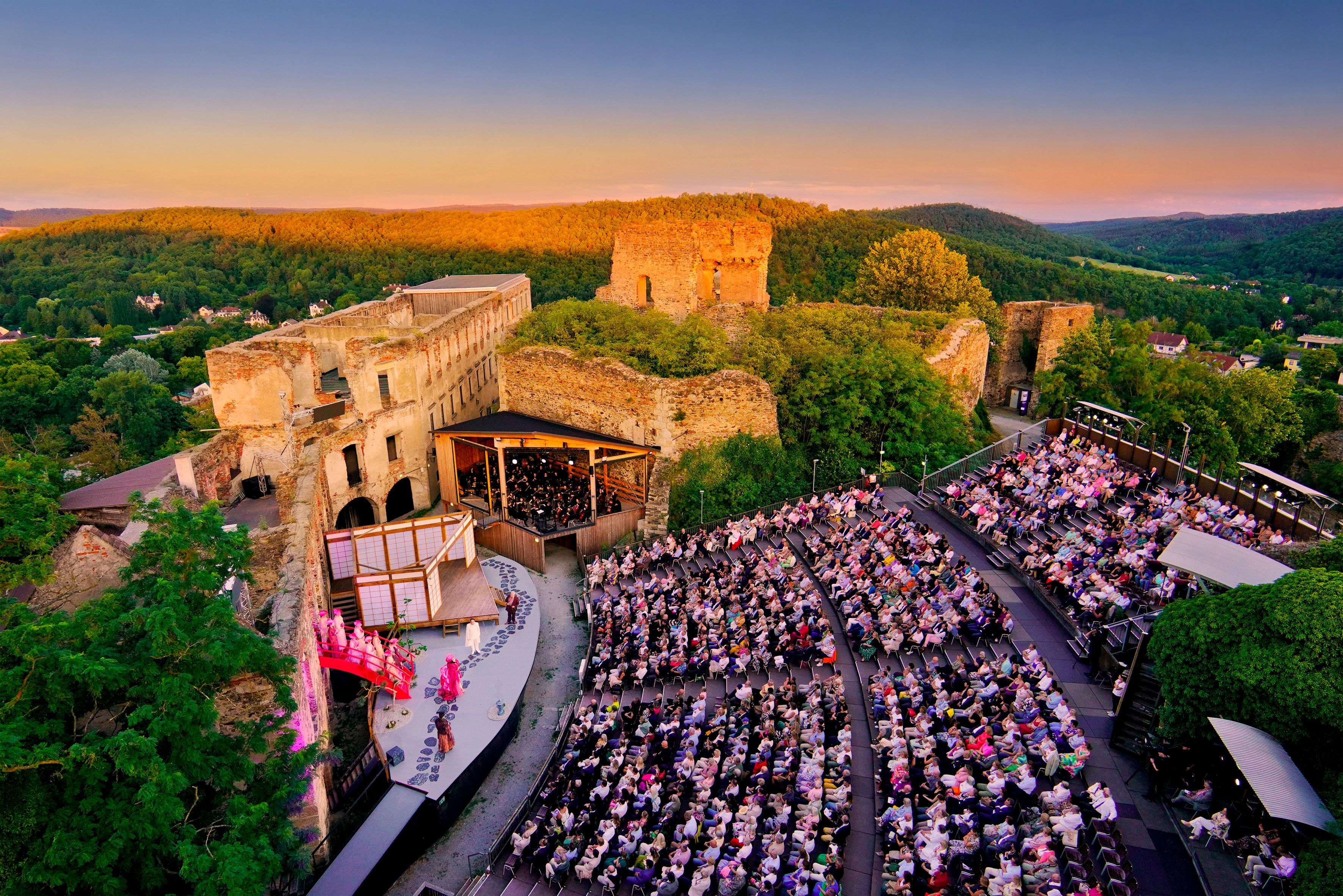 Eine Veranstaltung auf der Oper Burg Gars bei Sonnenuntergang mit vielen Menschen. 