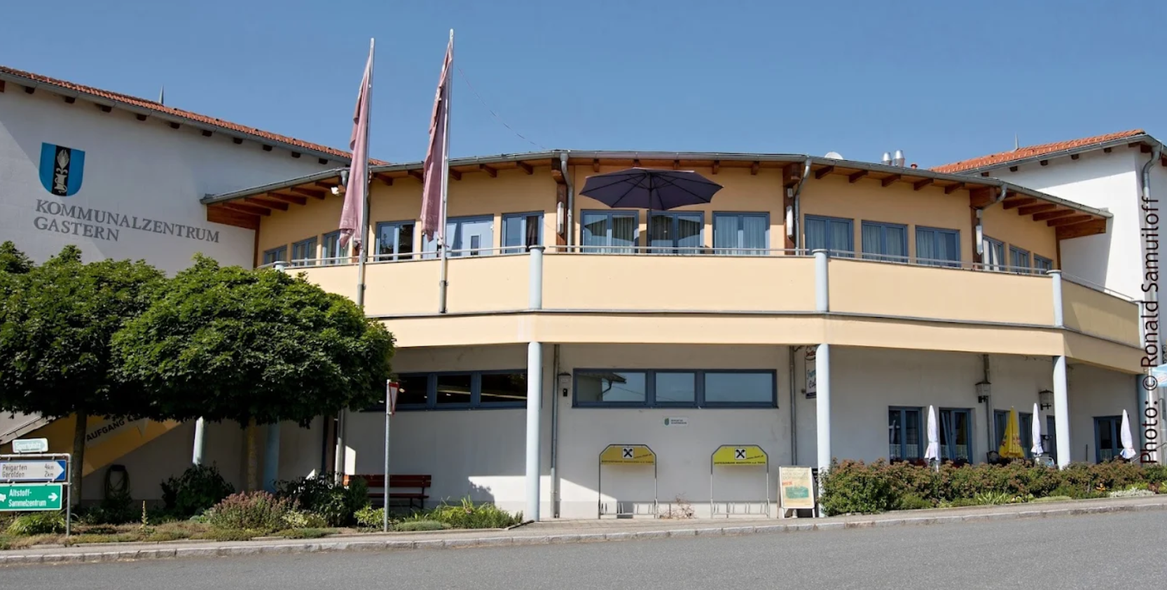 Außenansicht des Kommunalzentrums Gastern mit blauen Fenstern und gelber Fassade.