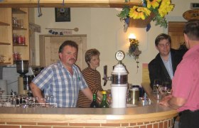 Innenansicht eines Heurigen mit Menschen an der Bar.