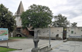 Stadtmauer und Museum in Horn mit Statue und Infotafel im Vordergrund.