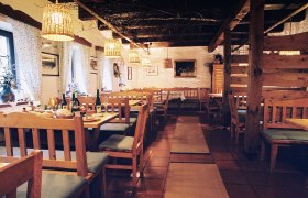 Gemütlicher Innenraum eines traditionellen Heurigen mit Holzmöbeln und gedeckten Tischen.