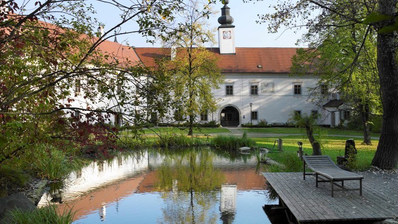 Inner courtyard of Schiltern Castle with pond and sun lounger.